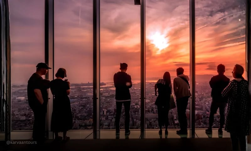 Tourists enjoying sunset views over Tokyo from a Shinjuku observation deck