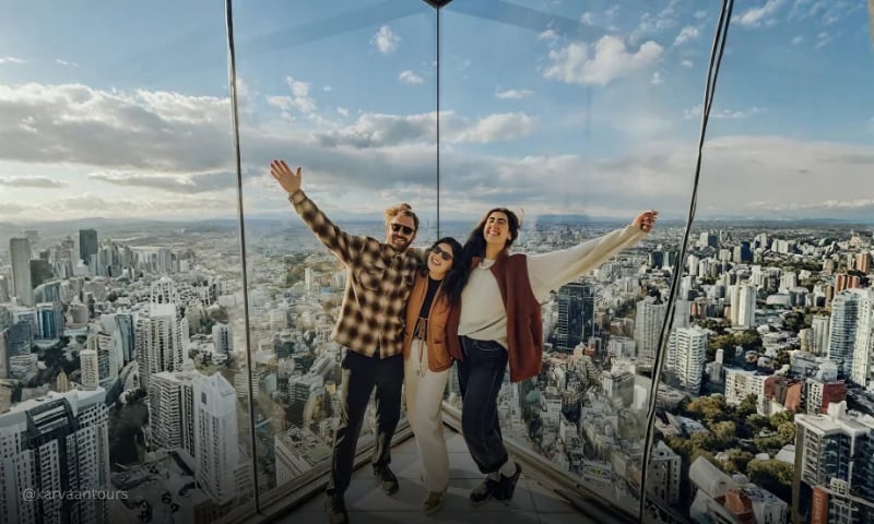 Travelers taking a selfie with panoramic Tokyo skyline views in the background