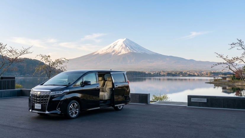 Luxury private car tour vehicle waiting at a scenic Mount Fuji viewpoint.
