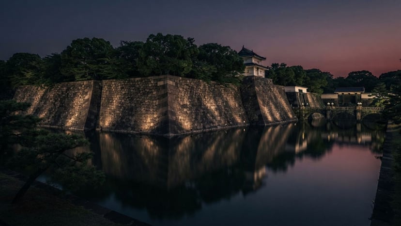 A view of the historic stone walls of the former Edo Castle moat at night.