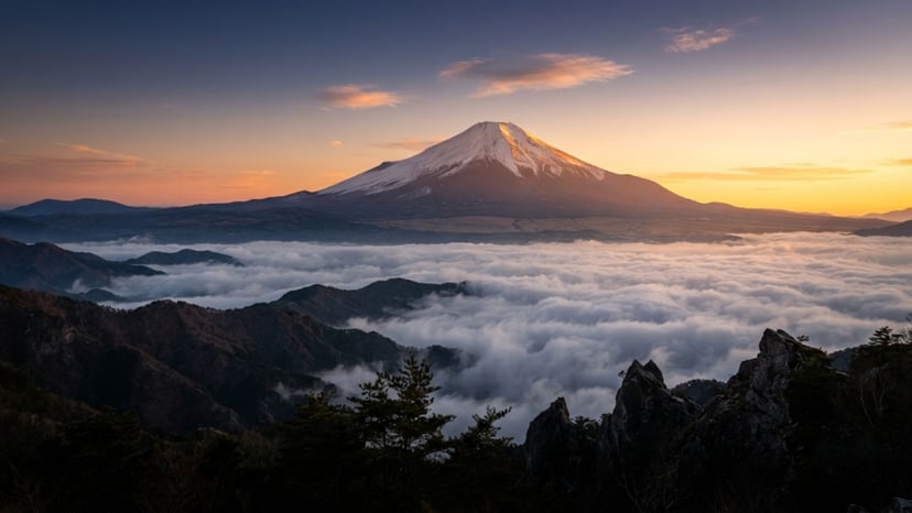 Golden early morning sunrise illuminating the summit of Mount Fuji above clouds